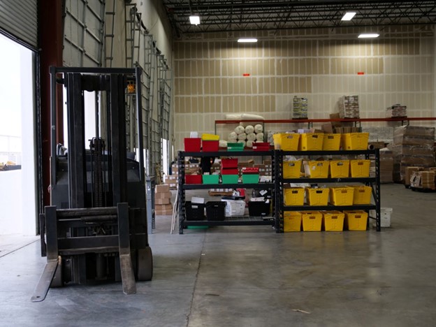 Photo of a forklift sitting in a warehouse receiving area.