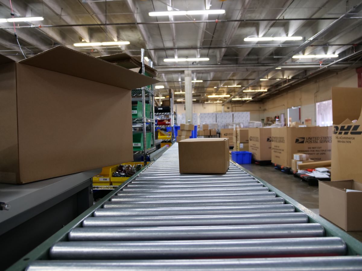 Close-up of a shipping box moving down a conveyor belt.