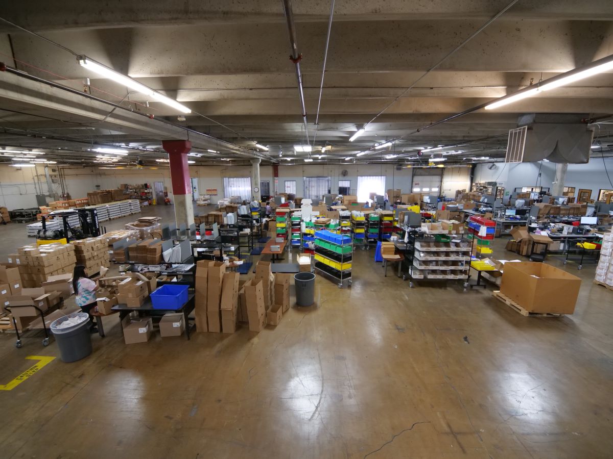 warehouse with boxes and bins. Clear floorspace looking out to a busy warehouse.