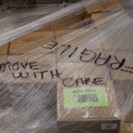 boxes wrapped on a pallet with the word fragile written on top