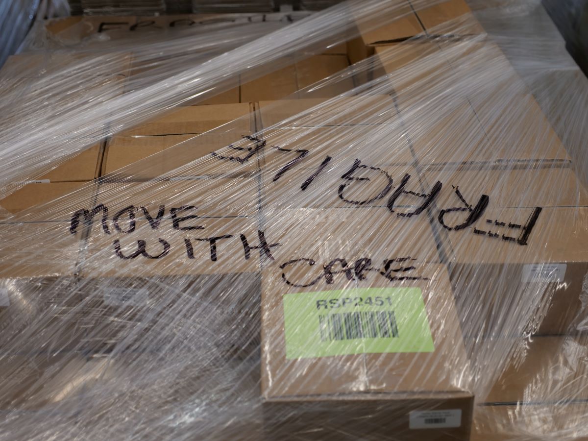 boxes wrapped on a pallet with the word fragile written on top