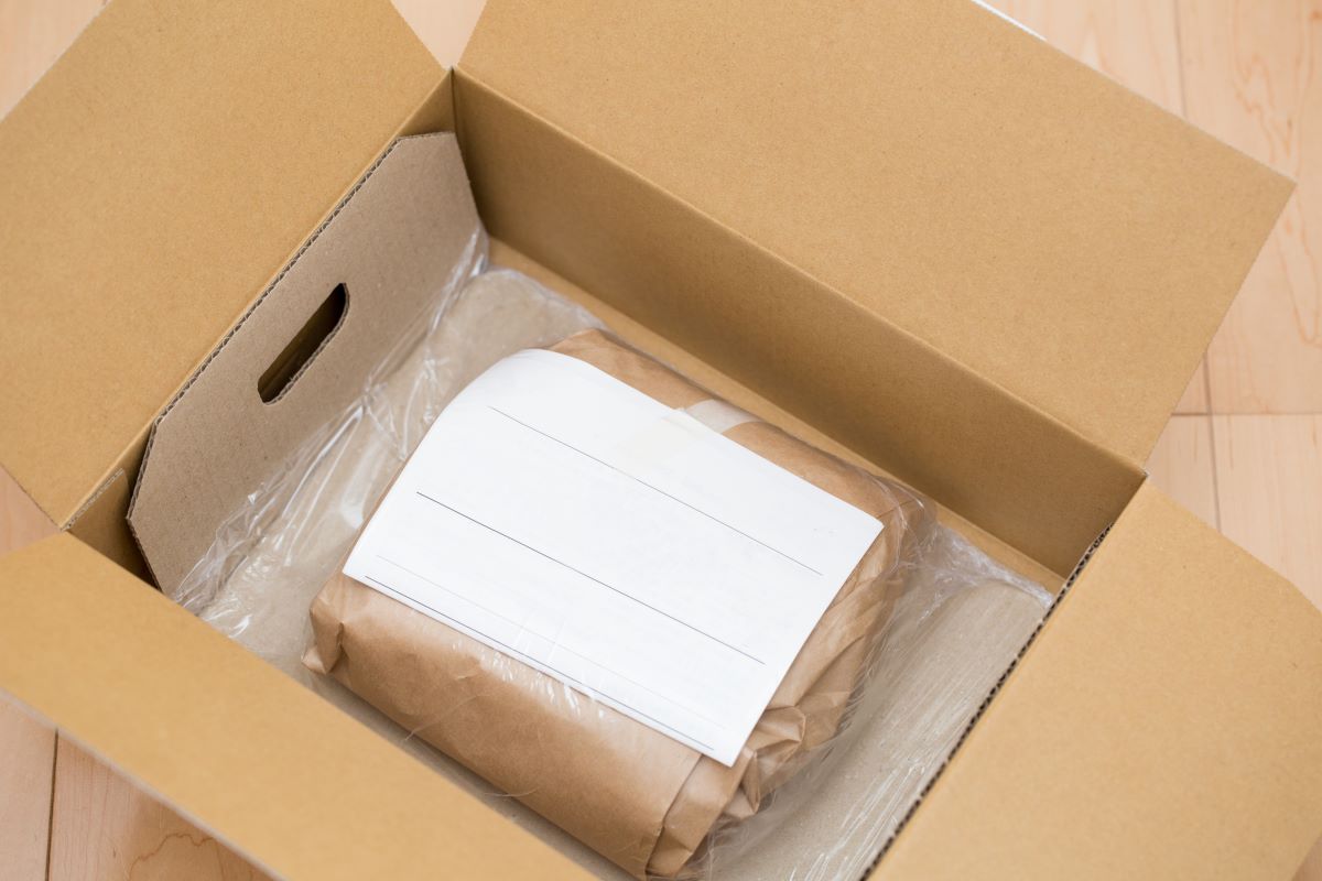 an open box with a product and packing slip on top.